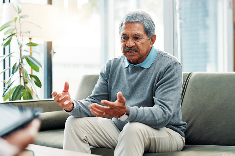 Older Mexican American man on therapy couch discussing anxiety and depression