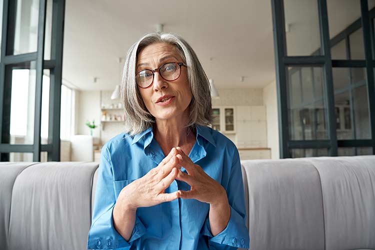 Mature woman with grey hair speaking to a relationship therapist
